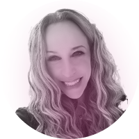 A woman with long, wavy hair smiles at the camera against a light background. The image has a soft, pinkish tint.